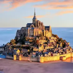 Mont Saint-Michel, jedno z najpiękniejszych miejsc we Francji, majestatycznie wznosi się z morza o zachodzie słońca.