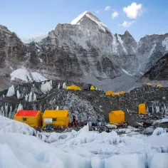 Obóz pod Mount Everest, gdzie jest Mount Everest, z żółtymi namiotami na lodowcu i surowymi, skalistymi górami w tle.