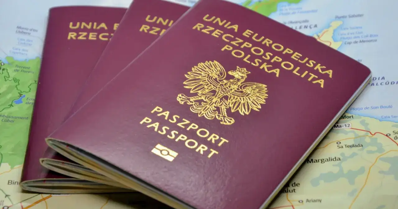 Trzy polskie paszporty leżą na mapie. Kto ma zniżkę na paszport, gdy planuje podróż?