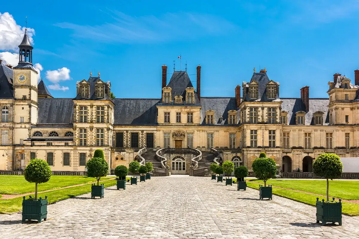 Zamek Fontainebleau, jedno z najpiękniejszych miejsc we Francji, z imponującymi schodami i zadbanym ogrodem.