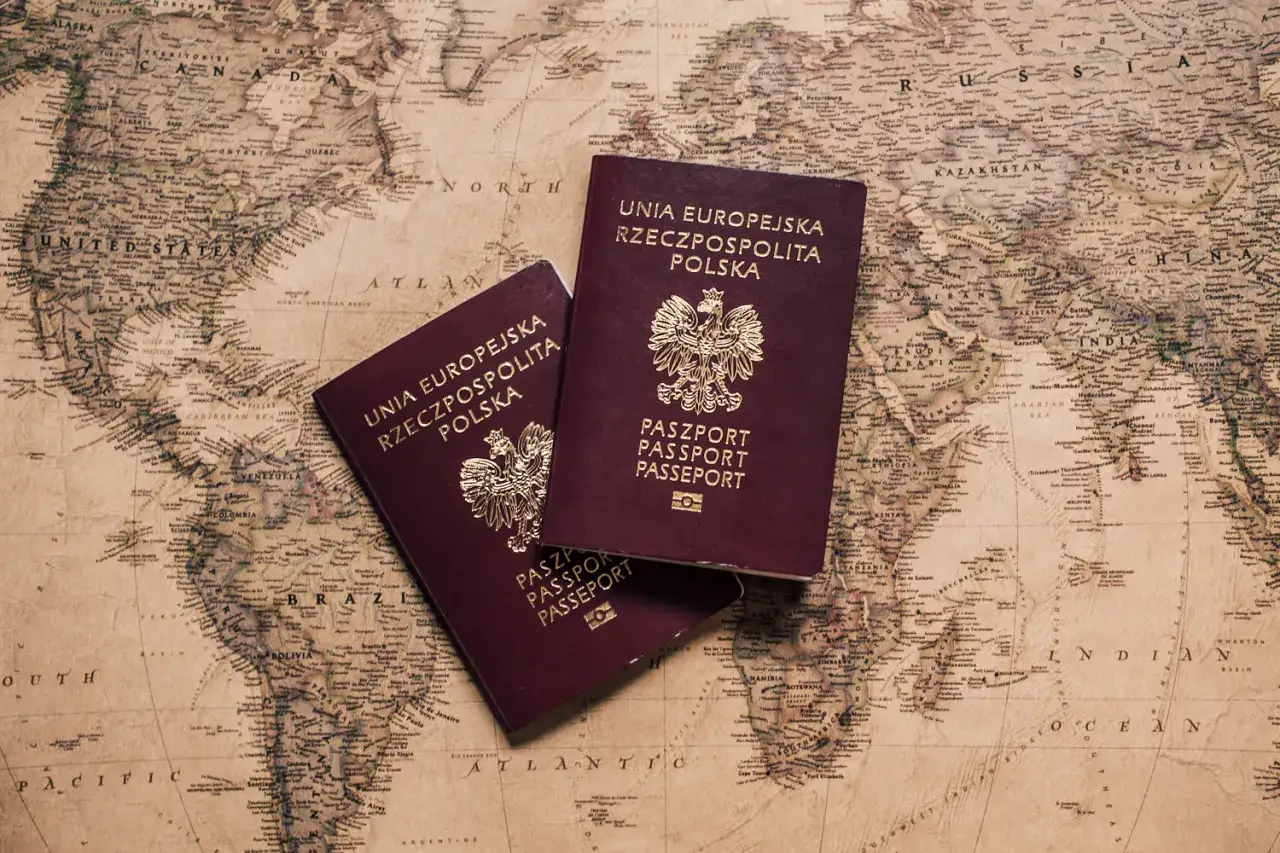 Dwa polskie paszporty leżą na starej mapie świata. Czas na nowe przygody, kiedy paszport traci ważność.