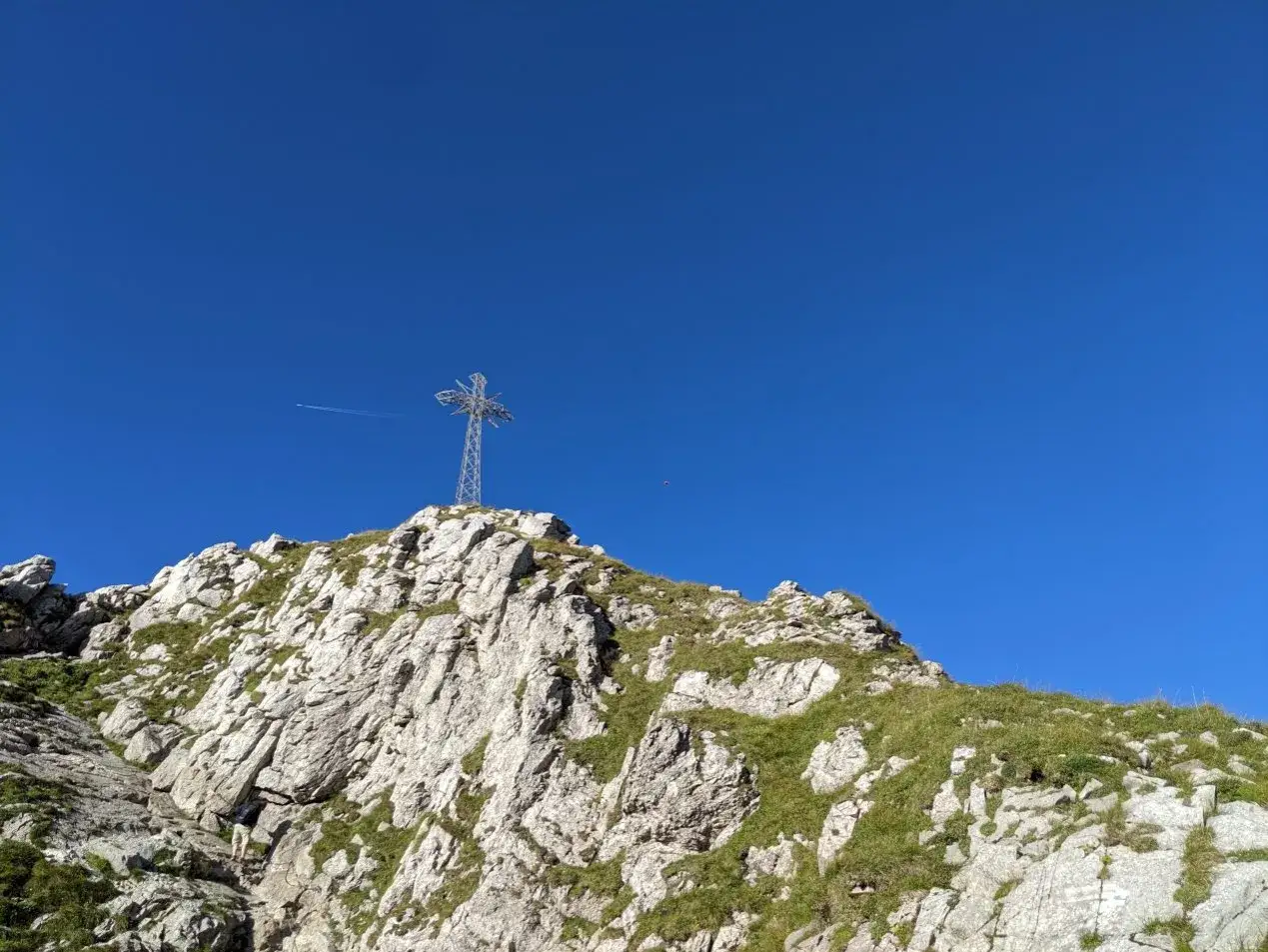 Giewont ile się wchodzi? Widok na szczyt z krzyżem i skalistym zboczem.