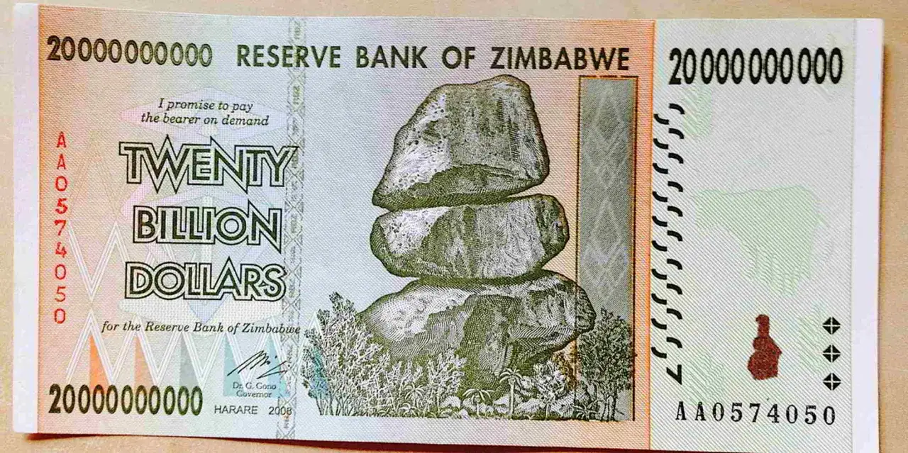 Banknot 20 miliardów dolarów Zimbabwe, kiedyś najtańsza waluta na świecie. Widok na stos kamieni i krajobraz.