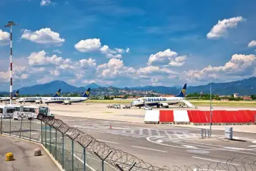 Samoloty Ryanair na lotnisku w Bergamo, gotowe do startu. Komunikacja miejska czeka na pasażerów.
