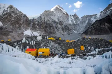 Obóz pod Mount Everest, gdzie jest Mount Everest, z żółtymi namiotami na lodowcu i surowymi, skalistymi górami w tle.
