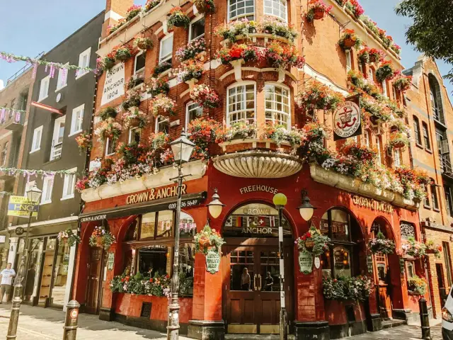 Uroczy pub Crown & Anchor w Londynie, ozdobiony mnóstwem kwiatów, to kwintesencja urokliwych dzielnic w Londynie.